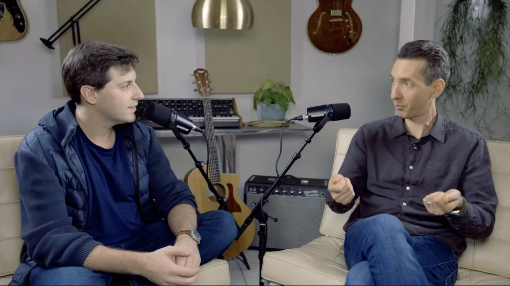 Two people sitting next to each other with microphones